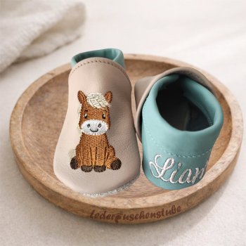 Lederpuschen in beige-pistazie mit Stickerei Pony Ida und links an der Ferse den Namen creme